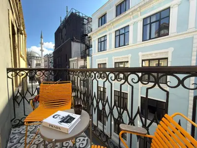 a balcony with two chairs and a table with a book on it at Taksim Square - Unique Loft for 12 Guests in Istanbul