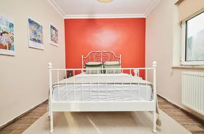a white bed in a room with a red wall at Stunning 3BR 3Bathroom 3AC near Metro D4 in Istanbul