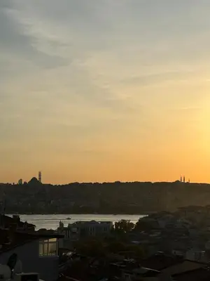 a sunset over a city with a river and buildings at 3BR,Charming Flat,Golden Horn View in Istanbul