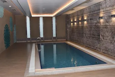 a swimming pool in a room with a tile wall at Yakut Suite in Istanbul