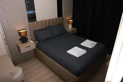 a small bedroom with a bed with two night stands at World Yours Luxury Suite - Beyoğlu in Istanbul