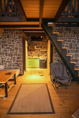 a staircase in a room with a chair and a table at Hill House Bungalov in Sapanca