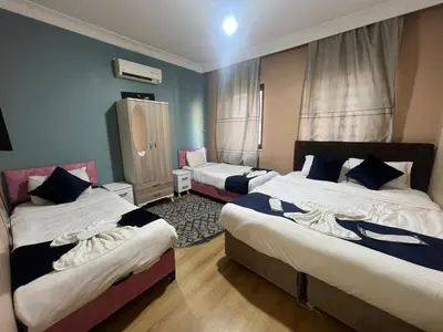 a hotel room with two beds and a chair at Taksim Luxury Mansion Hotel in Istanbul