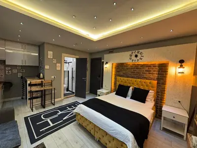a bedroom with a large bed and a kitchen at The Şişli No Va Park Suites in Istanbul