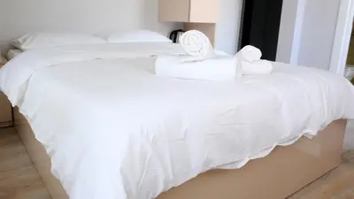 two beds with white sheets and towels on them at Rodax Residence in Istanbul
