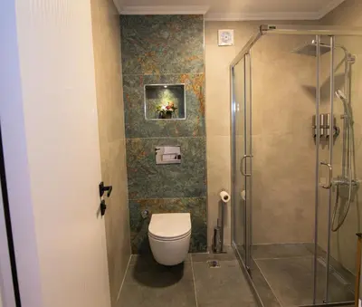 a bathroom with a toilet and a glass shower at Huzur Apart Hotel in Istanbul
