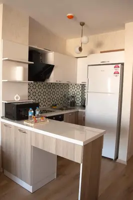 a kitchen with a white refrigerator and a counter at Luxe Suite AY38 in Eskiömerler