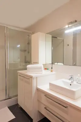 a white bathroom with a sink and a shower at CTS Elysium Residence Taksim in Istanbul