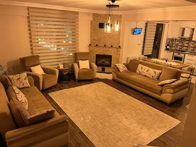 a large living room with couches and a fireplace at Lilyum garden house&organization in Söylemiş