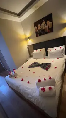 a bedroom with a bed with roses on it at Lions Boutique Hotel in Altınova