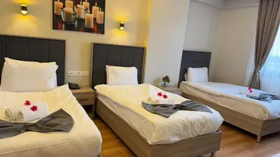 a room with three beds with flowers on them at Lions Boutique Hotel in Altınova