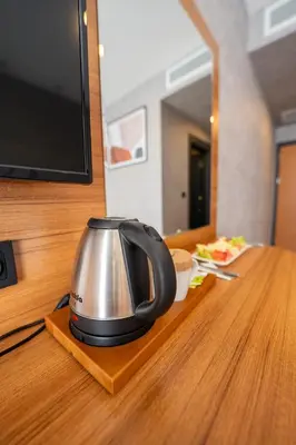 a tea kettle sitting on a wooden table next to a tv at Educity Hotels & Spa in Istanbul