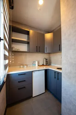 a kitchen with blue cabinets and a white dishwasher at Educity Hotels & Spa in Istanbul