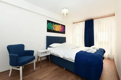 a bedroom with a bed and a blue chair at Historical Wood Dublex Apt at Taksim&Galata in Istanbul