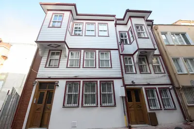 a white house with brown doors and windows at Historical Wood Dublex Apt at Taksim&Galata in Istanbul