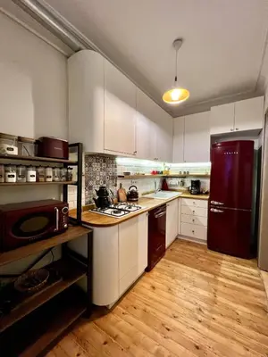 a kitchen with white cabinets and a red refrigerator at Old Town Loft in Balat in Istanbul