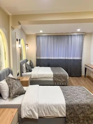 a hotel room with two beds and a window at Tophane Mansion Karakoy in Istanbul