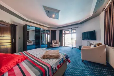 a bedroom with a bed and a chair and a television at Sapancada ısıtmalı havuzlu villa in Sapanca