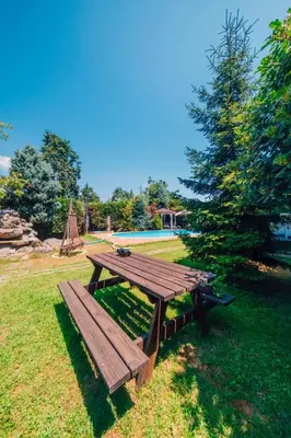 a wooden picnic table sitting in the grass at Sapancada ısıtmalı havuzlu villa in Sapanca