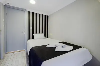 a bedroom with a large white bed with a black blanket at JAMMY Hotel in Istanbul