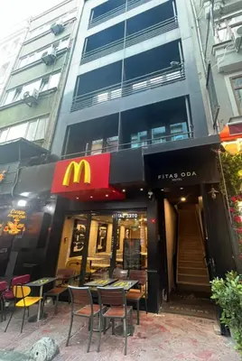 a mcdonalds restaurant with tables and chairs in front of a building at Fitas Oda Hotel in Istanbul
