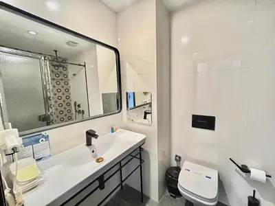 a white bathroom with a sink and a mirror at Fitas Oda Hotel in Istanbul
