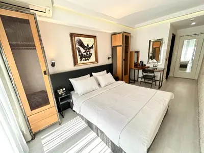 a bedroom with a large white bed and a desk at Fitas Oda Hotel in Istanbul