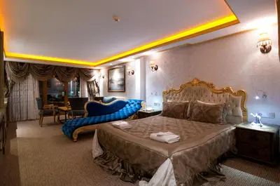 a bedroom with a large bed with a blue couch at Grand Ambiance Hotel in Istanbul