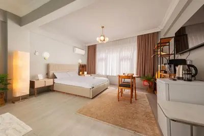 a bedroom with a bed and a table and a kitchen at Cozy Home in Historic Istanbul in Istanbul