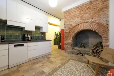 a kitchen with a brick fireplace and white cabinets at Casa Isabel - Amazing 5Br House in Prime Location in Istanbul