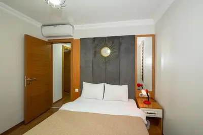 a bedroom with a bed and a wall with a mirror at Aras Life Hotel in Istanbul