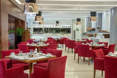 a dining room with tables and red chairs at Burgu Arjaan by Rotana Istanbul Asia in Istanbul