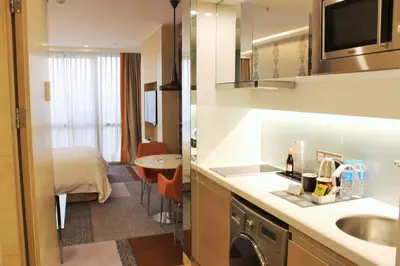 a kitchen with a sink and a room with a bed at Tango Arjaan by Rotana Istanbul Asia in Istanbul