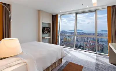 a bedroom with a large bed and a large window at Tango Arjaan by Rotana Istanbul Asia in Istanbul