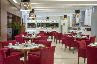 a dining room with tables and red chairs at Tango Arjaan by Rotana Istanbul Asia in Istanbul