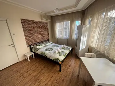 a bedroom with a bed in a room with a brick wall at Istanberry - Joker Apartments in Istanbul