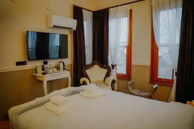 a hotel room with a bed and a tv at Leila Mansion Hotel in Tekirdag