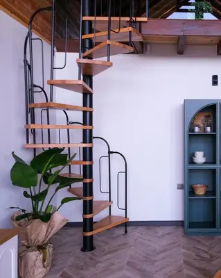 a spiral staircase in a room with a plant at Bell Garden Maşukiye in Kocaeli