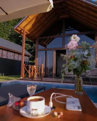 a table with a cup of coffee and a vase of flowers at Bell Garden Maşukiye in Kocaeli