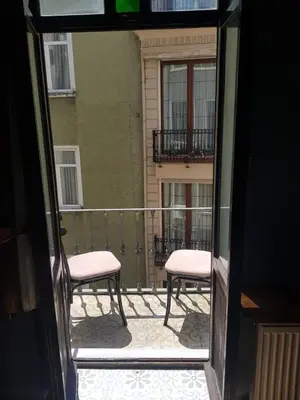 a view of a balcony with two pink chairs at TaksimAntiqueOtel in Istanbul