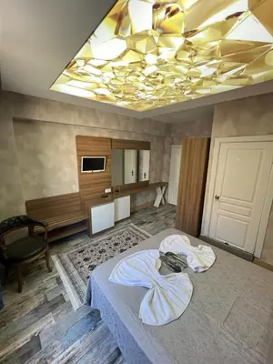 a bedroom with a large bed with a yellow ceiling at feridiye 71 in Istanbul