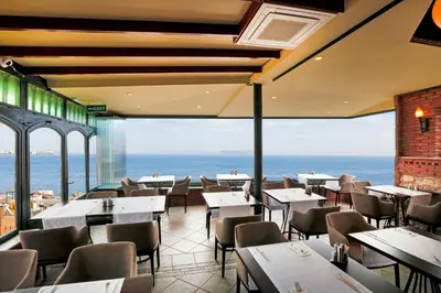 a restaurant with tables and chairs and a view of the ocean at Sultanahmet Palace Hotel in Istanbul