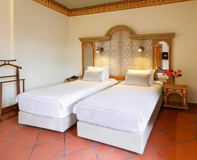 two beds in a hotel room with white sheets at Sultanahmet Palace Hotel in Istanbul