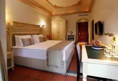 a bedroom with a large bed and a table at Sultanahmet Palace Hotel in Istanbul