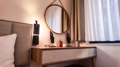 a mirror on a wall next to a bed at Agion Living Taksim Cihangir in Istanbul