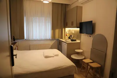 a small room with a bed and a small kitchen at Agion Living Taksim Cihangir in Istanbul