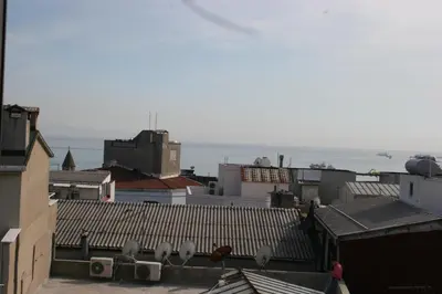 a view of roofs of buildings with the ocean in the background at Hotel Padova in Istanbul