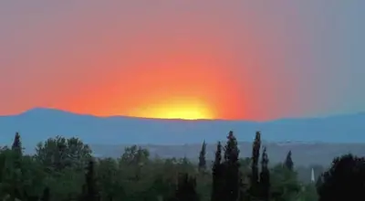 a sunset over a mountain range with trees in the foreground at Ada Villam in Sapanca