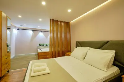 a bedroom with a large bed with a green couch at Daire 1 Jakuzili in Beylikduzu