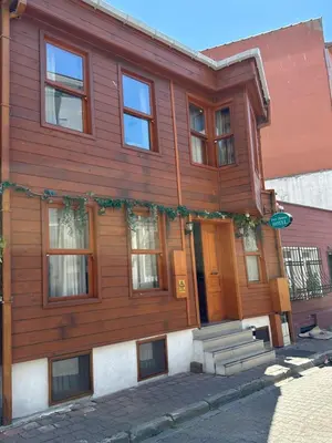 a wooden house with a front door and stairs at Tree House Otel in Istanbul